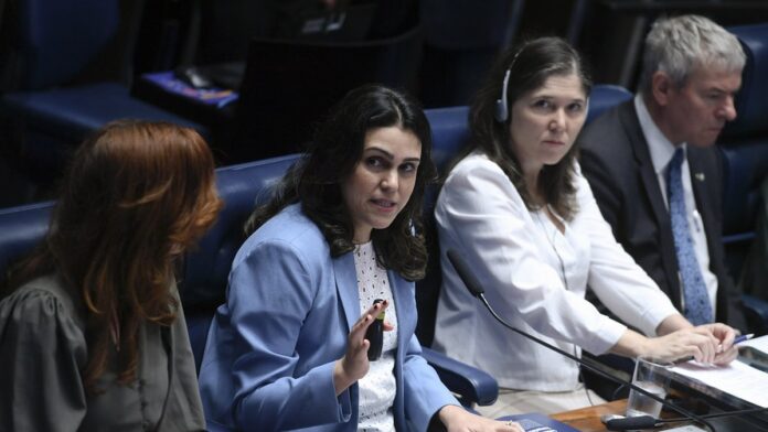 Executivo de terno observa telas com gráficos de dados e ícones de robótica em um escritório moderno.