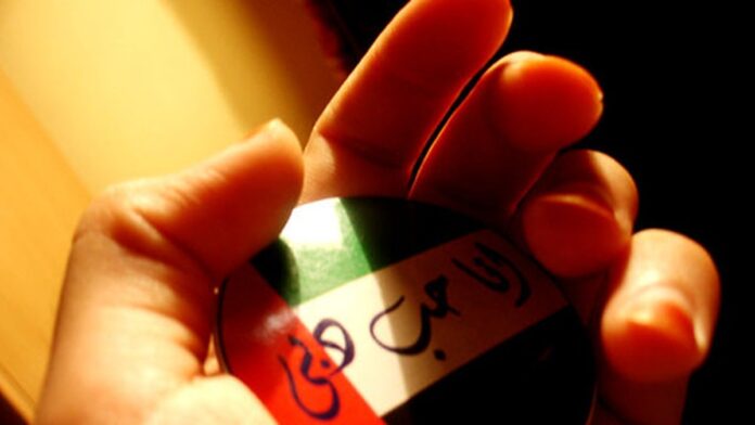 Petroleiro navegando em águas calmas próximo à costa, com fumaça escura saindo de uma estrutura metálica no convés.