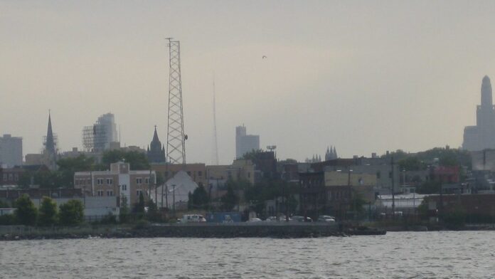 Ruínas de uma ponte de concreto parcialmente destruída sobre um rio, em meio a uma paisagem montanhosa e árida.