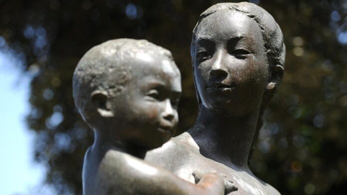 Vista aérea de fumaça subindo sobre construções urbanas ao entardecer, com céu tingido de laranja e tons escuros.