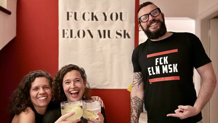 j-ri-dos-eua-conclui-que-elon-musk-enganou-acionis Foto de Elon Musk falando ao microfone durante evento, com expressão séria e fundo corporativo.