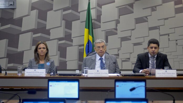 jani-polis-e-o-governo-do-paran-investem-r-11-8-mi Máquinas pesadas operam em uma estrada de terra em obras, com trabalhadores e materiais de construção ao fundo.