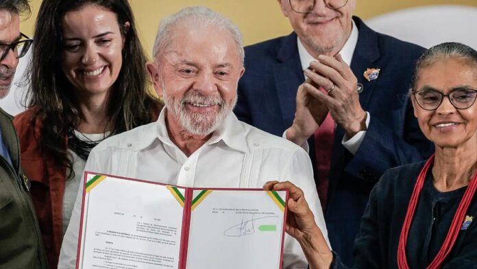 Presidente Lula assina decreto de proteção ambiental em meio a uma floresta preservada com vegetação densa e verde.