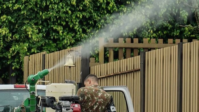 Enfermeira aplicando vacina em paciente, com mapa de Mato Grosso do Sul ao fundo.