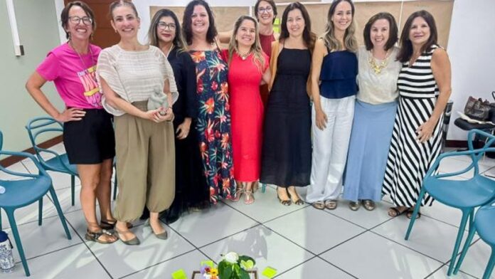 Grupo de pessoas sentadas em círculo em uma sala iluminada, participando de roda de conversa com foco em saúde.