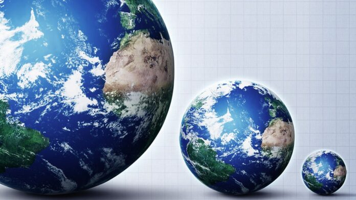 misoginia-nas-redes-como-atua-a-engrenagem-de-dio- Jovem sentado em um quarto escuro, iluminado apenas pela luz azulada de um computador, com expressão de concentração.