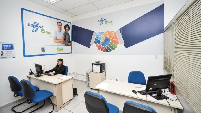 Ônibus urbano estacionado em via pública com passageiros entrando, em dia ensolarado.