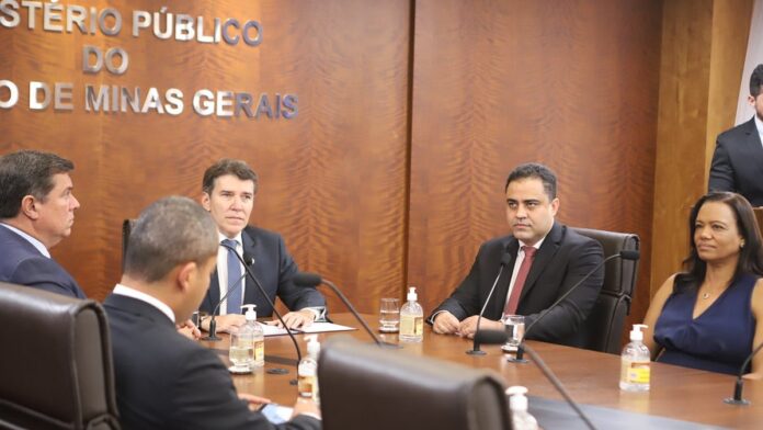 Técnico de saneamento coleta amostra de água em um rio para análise laboratorial em campo.