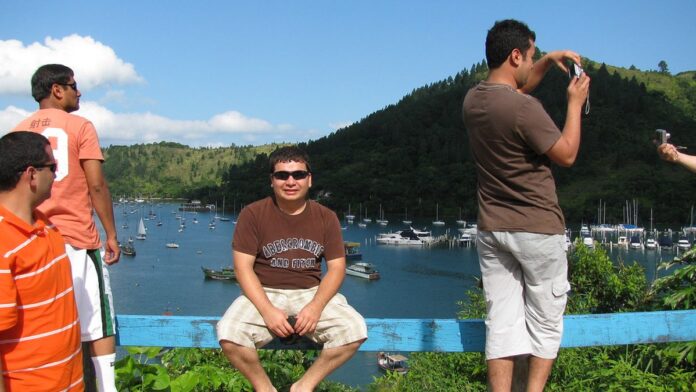 Viaturas da polícia e ambulância estacionadas ao lado de um ônibus parado no acostamento de uma rodovia.