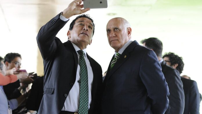 Fachada do prédio da Procuradoria-Geral da República, com bandeiras do Brasil ao fundo sob céu azul.