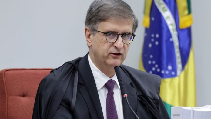 Jair Bolsonaro sentado em um ambiente interno, olhando para o lado, com expressão séria. Foto em plano médio.