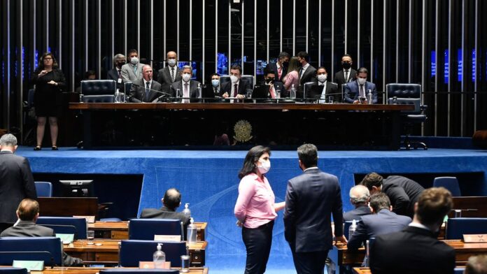 Pilha de processos judiciais e documentos sobre uma mesa de escritório, simbolizando a espera por pagamentos.