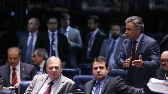 Atendentes do Procon atendem consumidores em mesas organizadas em um salão para renegociação de dívidas.