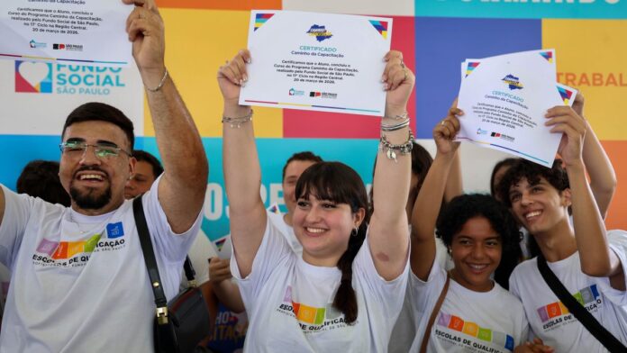 Grupo de formandos sorridentes recebendo certificados em cerimônia oficial do programa de capacitação em São Paulo.