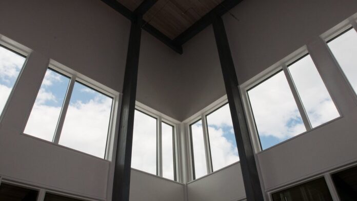 Joe Biden discursa em um pódio com símbolos oficiais dos EUA, tendo ao fundo bandeiras americanas e painéis solares.