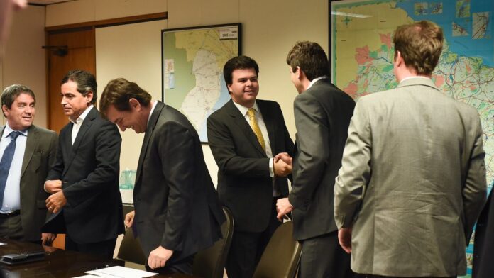 Rafael Marques, ex-jogador, posa com uniforme de treinador em campo de futebol durante coletiva de apresentação.