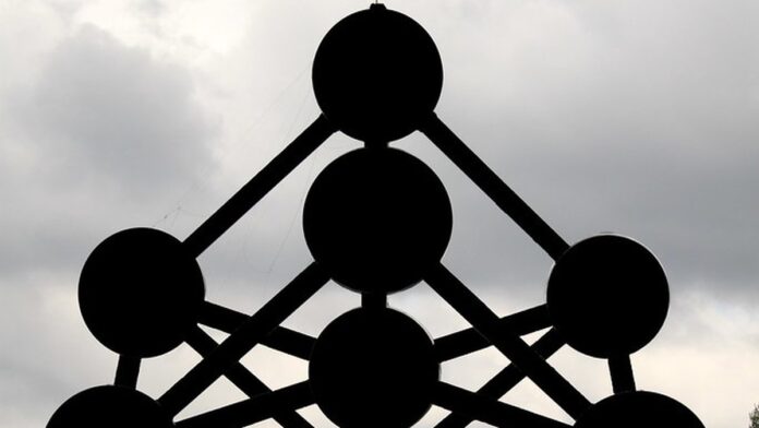 Jogador de futebol com uniforme verde e branco do Guarani em campo, olhando para o horizonte com expressão pensativa.