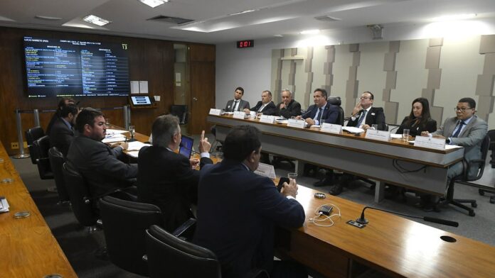Representantes de comunidades quilombolas em roda de conversa, discutindo mapas e documentos sobre posse de terras.