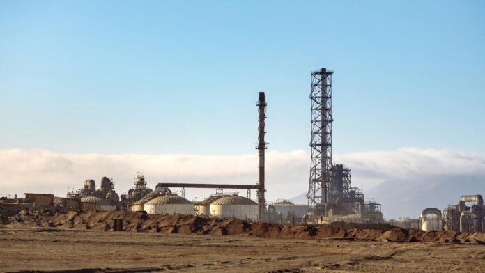 A refinery in a desert setting, showcasing energy production and industrial machinery.