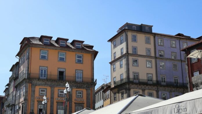 s4-34f1e890d041 Elegant historic buildings in Porto's city center, showcasing vibrant architectural beauty under a clear blue sky.