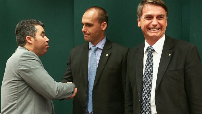 Brasília - O deputado Marcos Rogério cumprimenta Eduardo Bolsonaro ao lado de Jair Bolsonaro após o Conselho de Ética arquiva