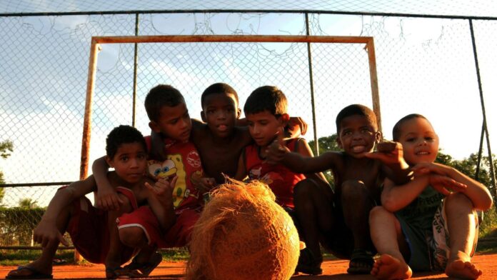 s4-53455c546bca Group of kids enjoying a lively game of soccer in a Rio de Janeiro neighborhood.
