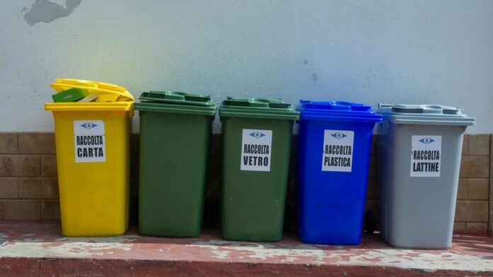 Five colorful recycling bins organized for waste segregation in an urban setting.