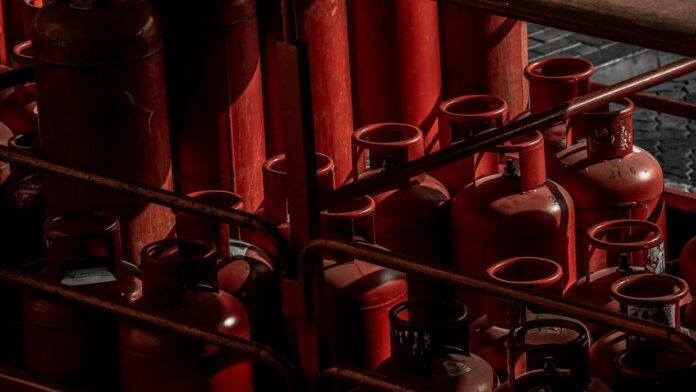 A collection of red gas cylinders stored in an industrial setting, Dubai.