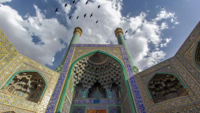 Stunning view of traditional Islamic architecture with intricate mosaics and minarets in Isfahan, Iran.