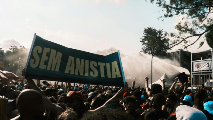 Large crowd demonstrating with a 'Sem Anistia' banner, conveying a powerful protest message.