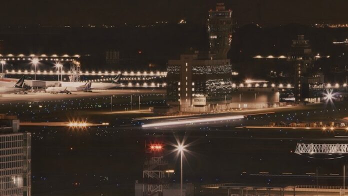 a night time view of an airport with planes parked