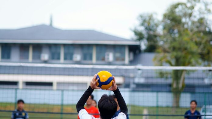 Youth playing volleyball outdoors captures active sports energy and teamwork.