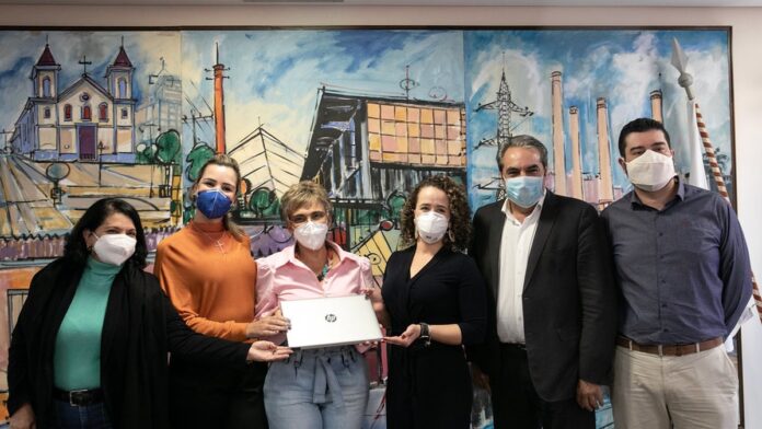 Gestores educacionais sentados em uma mesa redonda, discutindo documentos e alinhando estratégias pedagógicas.