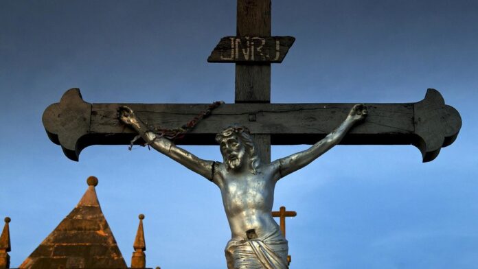 Fiéis acompanham procissão pelas ruas históricas de pedra em Oeiras durante a Semana Santa.