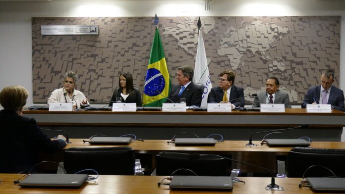 Fachada do prédio do Superior Tribunal de Justiça (STJ) em Brasília, com foco nas colunas imponentes e brasão nacional.