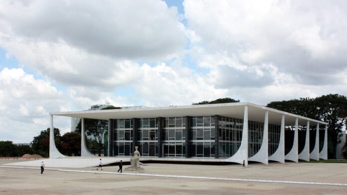 Guindaste de construção parado em um canteiro de obras urbano sob um céu nublado, indicando paralisação de projeto.