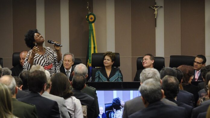 tcu-avan-a-em-comiss-o-para-discutir-flexibiliza-o Fachada de uma usina termoelétrica com chaminés e estruturas metálicas sob céu azul.