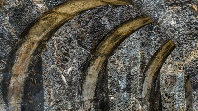 Céu parcialmente nublado com nuvens carregadas de tempestade em contraste com forte luz solar sobre uma rua brasileira.