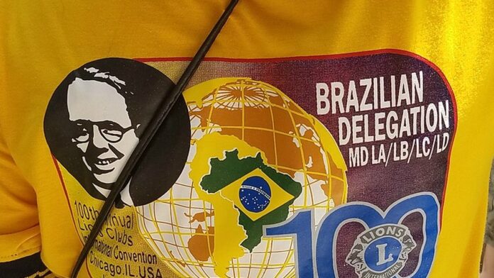 Operário de capacete utiliza ferramentas manuais para substituir tubulações metálicas antigas em vala de obra urbana.