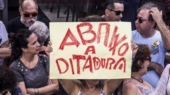 Fachada de escola pública com diversos bares e lanchonetes vendendo salgadinhos e doces industrializados ao redor.