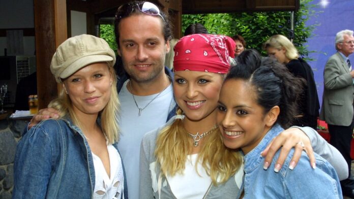 Foto em close de uma mulher de expressão séria e decidida, olhando para a câmera em um ambiente iluminado.