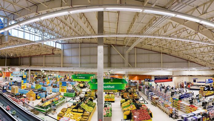 walmart-anuncia-etiquetas-digitais-de-pre-o-em-tod Etiqueta de preço digital fixada na prateleira de um supermercado, exibindo o valor do produto em uma tela pequena.