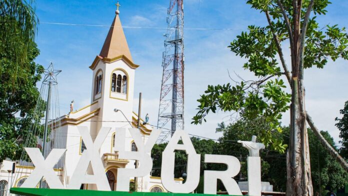 Vista aérea de Xapuri com ruas pavimentadas e áreas verdes preservadas, destacando a integração urbana e a natureza.