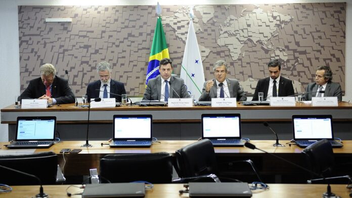Jogador do Botafogo-SP com uniforme tricolor corre em campo de futebol durante partida oficial.