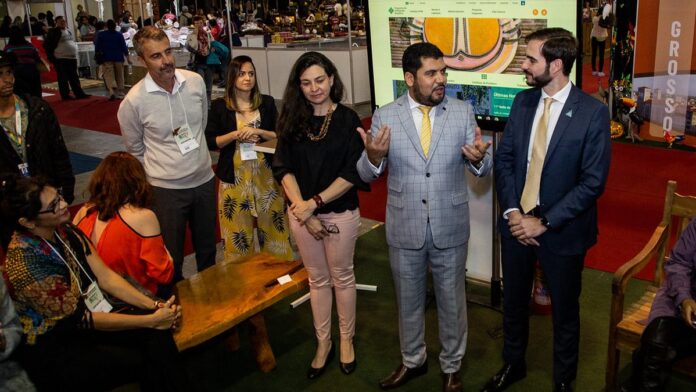 Artesão paraense expõe peças de cerâmica marajoara e objetos artesanais coloridos em estande no Salão do Artesanato.