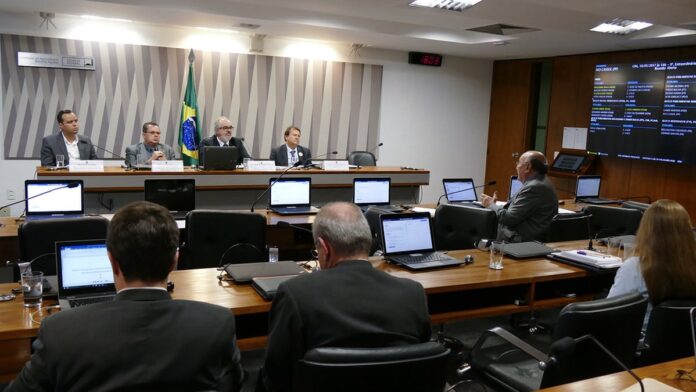 Técnicos da Adepará em campo utilizando tablets para monitoramento agrícola de pragas em pomar de carambolas.