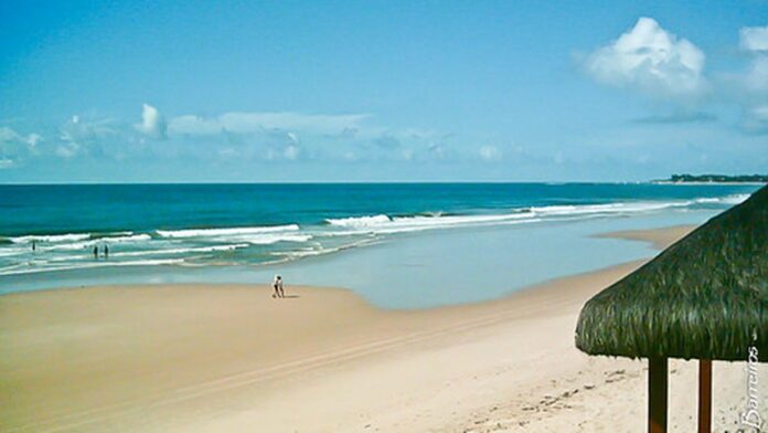 Nuvens carregadas e escuras sobre uma paisagem urbana com ruas molhadas, indicando temporal iminente.