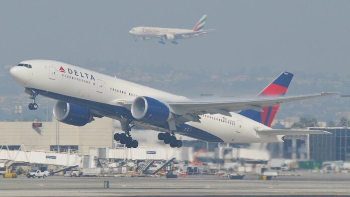 Interior de cabine de avião com poltronas e telas de entretenimento ligadas, exibindo o logotipo da Amazon.