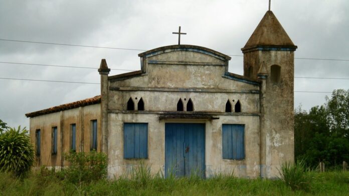 Vários tambores metálicos azuis empilhados em um galpão, contendo mel apreendido pelas autoridades ambientais.