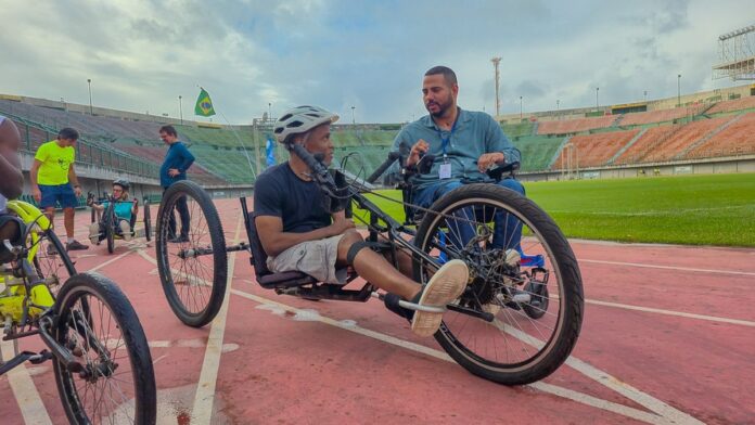 Jogadoras de futebol com uniformes do Bahia e América-MG disputam a posse de bola em um campo de grama verde.